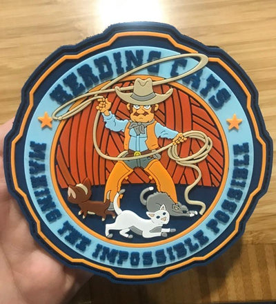  Herding Cats PVC Patch with text “Making The Impossible Possible” from Challenge Coin Nation. Shows cowboy spinning a lasso near three cats.