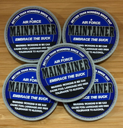  Five MX Skoal Patches arranged on a wooden surface. Text on the patches reads: “Better than nonners since 1947. Air Force Maintainers. Embrace the suck. Warning: Working in MX can cause foul language and high tolerance to alcohol.”