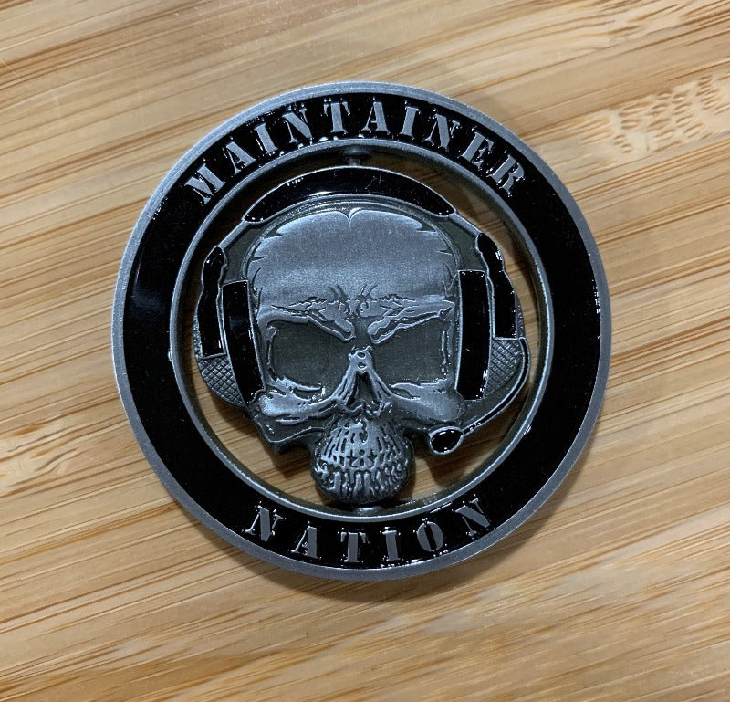 MX Spinner Coin with die-cut center skull and headset logo on wooden surface, from Challenge Coin Nation