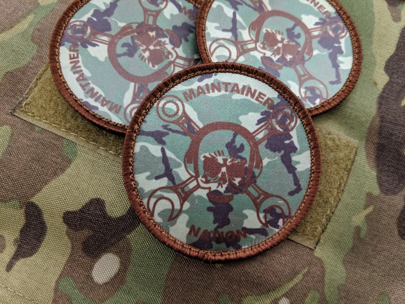  Three Maintainer Nation OCP Dye-Sublimated Morale Patches from Challenge Coin Nation on a camo fabric background 